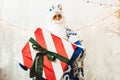 Santa Claus in a blue fur coat against the background of a garland gives a gift to the camera Royalty Free Stock Photo