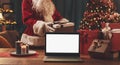 Santa Claus bringing Christmas, gifts and laptop Royalty Free Stock Photo