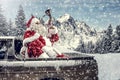 Santa Claus in a car driving to deliver some christmas presents on a sunny winter day. Blurred mountain forest background. Royalty Free Stock Photo