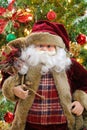 Santa Claus carrying a sack bag with Christmas tree background Royalty Free Stock Photo