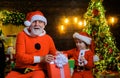 Santa Claus and Santa child boy at home with Christmas gift. Happy family holidays. Smiling little Santa helper and Royalty Free Stock Photo