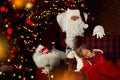 Santa Claus with Christmas gifts standing near sleeping little girl Royalty Free Stock Photo
