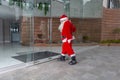 Santa Claus at Christmas opens a glass door of a modern building to enter Royalty Free Stock Photo