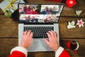 Santa claus with christmas presents having video call with happy caucasian family Royalty Free Stock Photo