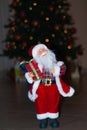 Santa Claus at Christmas time, with a Christmas tree behind Royalty Free Stock Photo