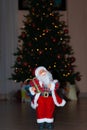 Santa Claus at Christmas time with tree, gifts and bokeh Royalty Free Stock Photo