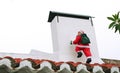 Santa Claus climbing the chimney Royalty Free Stock Photo