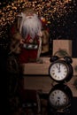 Santa Claus, clock and christmas gift on a black background Royalty Free Stock Photo