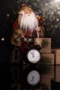 Santa Claus, clock and christmas gifts on a black background Royalty Free Stock Photo