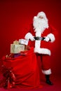 Santa Claus comes with a big bag of gifts. Full length portrait