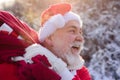 Santa Claus coming to the winter forest with a bag of gifts, snow landscape. Royalty Free Stock Photo