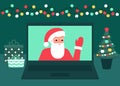 Santa Claus communicate online on Christmas holiday on laptop at home. Decoration fir, lightbulbs desktop and greeting
