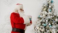 Santa Claus decorating Christmas tree with baubles Royalty Free Stock Photo