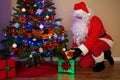 Santa Claus delivering presents under the tree.