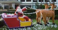 Santa Claus delivers gifts in a sleigh drawn by reindeer, decorative garden sculpture, summer Christmas