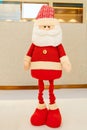 a Santa Claus doll in the indoor vertical composition