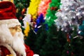 Santa Claus doll on various colors of Christmas trees background Royalty Free Stock Photo