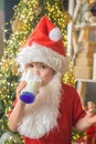 Santa Claus eating cookies and drinking milk on Christmas Eve. Happy santa claus eating a cookie and drinking glass of Royalty Free Stock Photo