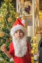 Santa Claus eating cookies and drinking milk on Christmas Eve. Kid Santa Claus enjoying in served gingerbread cake and Royalty Free Stock Photo