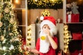 Santa Claus eating cookies and drinking milk on Christmas Eve. Little Santa picking cookie and glass of milk at home Royalty Free Stock Photo