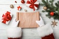 Santa Claus with empty wish list at table, top view. Christmas celebration Royalty Free Stock Photo