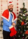 Santa Claus with excited face near Christmas tree and garlands Royalty Free Stock Photo