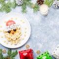 Santa Claus face made of fruits and marshmallow on a plate. Christmas food for children. Top view Royalty Free Stock Photo