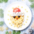 Santa Claus face made of fruits and marshmallow on a plate. Christmas food for children. Top view Royalty Free Stock Photo