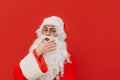 Santa Claus in fancy eyeglasses and a red costume is feeling thoughtful and touching his beard with his hand. Pensive Santa is Royalty Free Stock Photo