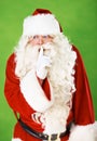 Santa claus, finger and quiet secret in studio for Christmas surprise, celebration or holiday excitement. Male person Royalty Free Stock Photo