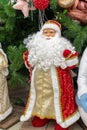 Santa Claus full-length, life-size doll in a Santa costume, a lush white curly beard. Toy Santa Claus standing under the Christmas