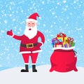Santa Claus with gift bag and present gifts standing up with falling snow Royalty Free Stock Photo
