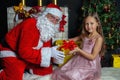 Santa Claus and a girl in a dress. Christmas Scenes. Royalty Free Stock Photo