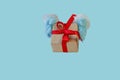 Santa Claus gives a present - gift box with red ribbon, copy space isolated on light blue. Concept for Christmas gifts Royalty Free Stock Photo