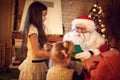 Santa Claus giving Christmas gifts to children Royalty Free Stock Photo