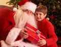 Santa Claus Giving Gift To Boy In Front Of Christm Royalty Free Stock Photo