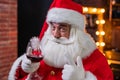Santa claus with a glass of red wine wishes merry christmas and says toast Royalty Free Stock Photo