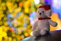 Santa claus glitter white teddy bear wearing hat sitting in front of colorful bokeh lights Royalty Free Stock Photo