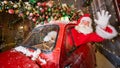 Santa claus greeting while driving a red retro car. Merry Christmas Royalty Free Stock Photo