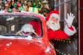 Santa claus greeting while driving a red retro car. Merry Christmas Royalty Free Stock Photo