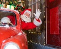 Santa claus greeting while driving a red retro car. Merry Christmas Royalty Free Stock Photo