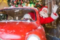 Santa claus greeting while driving a red retro car. Merry Christmas Royalty Free Stock Photo