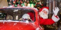 Santa claus greeting while driving a red retro car. Merry Christmas. Widescreen. Royalty Free Stock Photo