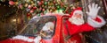 Santa claus greeting while driving a red retro car. Merry Christmas. Widescreen. Royalty Free Stock Photo