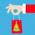 Santa Claus hand holding gift shopping paper bag with fir tree. Merry Christmas. Red costume fur. Giving present. Cute cartoon kaw