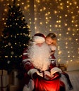 Santa Claus with happy little cute children boy and girl near Christmas tree Royalty Free Stock Photo