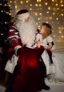 Santa Claus with happy little cute children boy and girl near Christmas tree Royalty Free Stock Photo