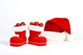 Santa Claus hat and boots with red and matt christmas balls on snow in front of white background