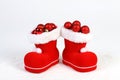 Santa Claus hat and boots with red and matt christmas balls on snow in front of white background