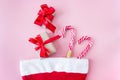 Santa Claus hat with gift box and caramel staff on a pink background Royalty Free Stock Photo